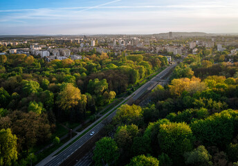 Aerial view of Park of Polish Aviators with road and city buildings in Krakow, Poland during spring sunset.