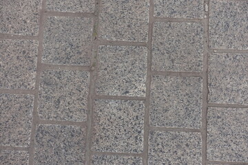 Macro of pavement made of gray unpolished granite stone blacks