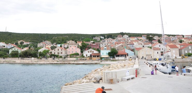 Unije, Croatia, 19th August, 2023. Port on the Croatian island of Unije and tourist on the dock. The village Unije at the island Unije in Croatia..Yachts anchored in port on the island of Unije