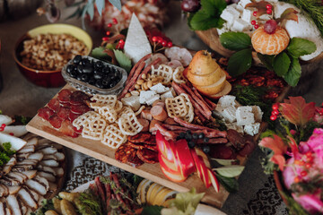 A table full of food with a variety of meats, fruits, and vegetables. The table is set for a party or gathering