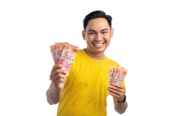 Excited young Asian man holding lots of cash banknotes with happy expression isolated on white background