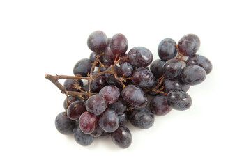 Bunch of organic black grapes isolated on white background.
