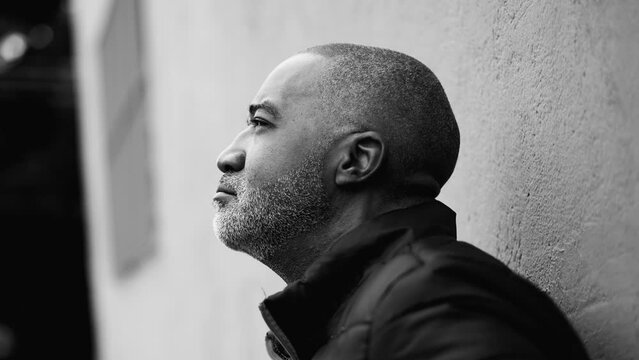 One thoughtful senior man looking up sky with pensive gaze struggling with difficulties and challenging times captured in monochromatic, black and white