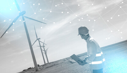 Engineer using laptop for wind turbine inspection; light effect