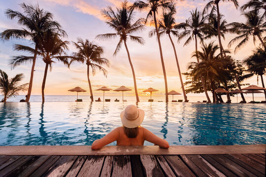 holidays travel, woman relaxing in swimming pool of luxurious hotel resort