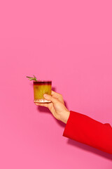 Female hand holding cocktail with orange juice against pink background. New York sour traditional cocktail. Concept of alcohol and non-alcohol drink, party, holidays, bar. Poster. Copy space for ad - obrazy, fototapety, plakaty