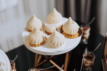 A white plate with a dessert on it. The dessert is a pastry with a swirl on top. There are five of these pastries on the plate