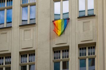 rainbow flag hanging from a window as a sign of tolerance