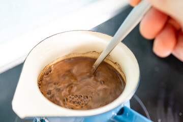 Add aromatic ground coffee to the coffee pot with a spoon and prepare excellent coffee.