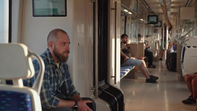 Tired man yawns, rides from work in a subway train car. Resident of suburb goes to work in the early morning by public transport. Man with backpack use metro. Adult in Public transportation.