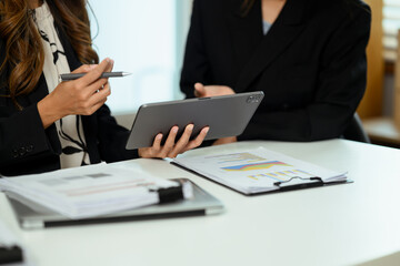 Cropped shot of businesswoman discussing work issues and using digital tablet at office table