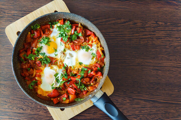 Tasty and Healthy Shakshuka in a Frying Pan. Eggs Poached in Spicy Tomato Pepper Sauce