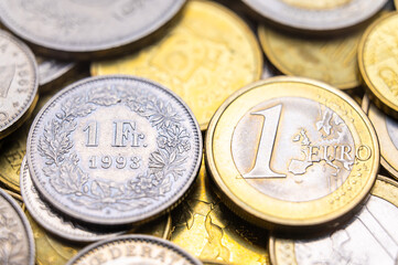 Euro and Swiss Franc coins next to each other, 1 euro and 1 CHF coins