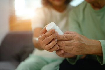 Cropped shop of senior couple reading medicine instruction on packaging before take pill. Healthcare concept