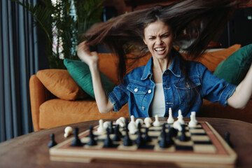 Woman Engrossed in Intense Chess Match, Hair Fluttering in Breeze, Sitting on Couch
