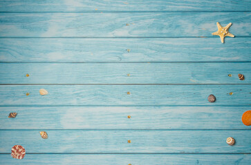 Sea shells and starfish on a blue wooden background. Top view, copy space
