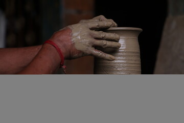 The potter works on a pottery wheel to made of soft colored clay, retro style toned Clay pots with...