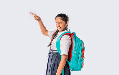 Portrait of cheerful Indian asian teenage schoolgirl with school uniform and backpack