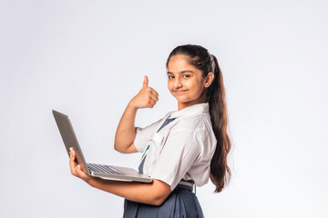Indian asian schoolgirl in school uniform holding laptop isolated on white background