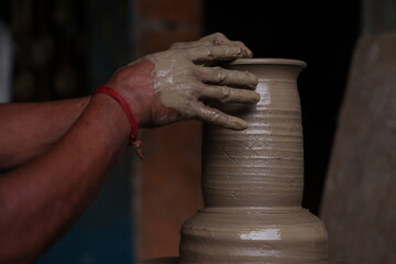 The potter works on a pottery wheel to made of soft colored clay, retro style toned Clay pots with hand and equipment