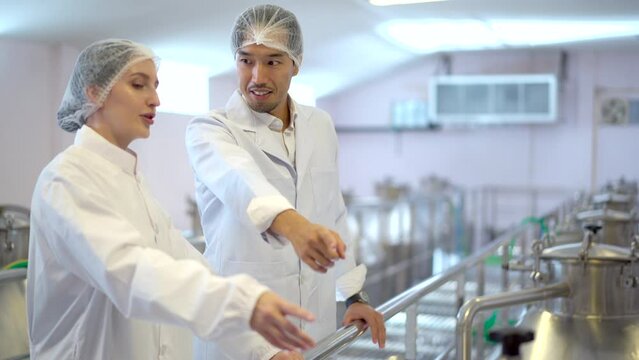 Supervisors examining a manufacturing production line in factory.