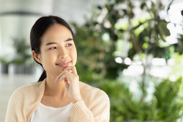 Fototapeta na wymiar Thoughtful and confident asian woman thinking about good idea with positive mood