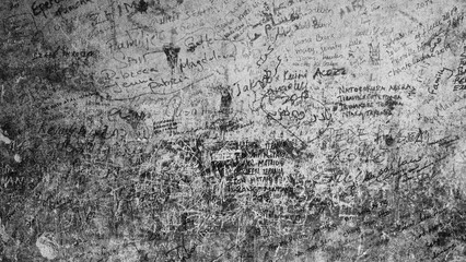Graffiti Wall Full Of Names And Scribbles, Textured Close-Up In Monochrome