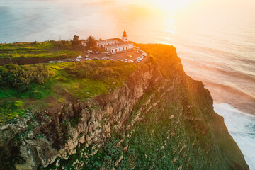 Aerial view of rough ocean with waves, volcanic beach, sunset over a huge cliff  in Lighthouse...