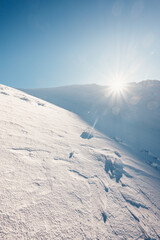 Alpine mountains landscape with white snow and blue sky. Sunset winter in nature. Frosty trees...