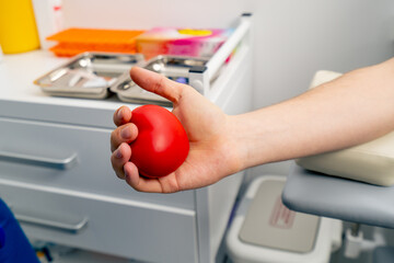 Obraz premium close-up in the clinic a guy pumps blood with a spanner to draw blood healthy life