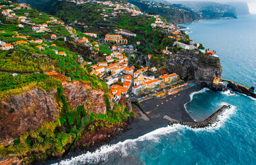 Aerial view of rough ocean with waves, volcanic beach in Ponta do Sol, Madeira, Portugal