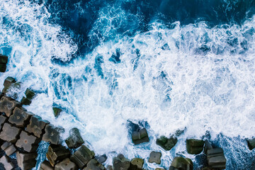 Aerial view of rough ocean with waves, volcanic beach in Ponta do Sol, Madeira, Portugal