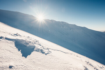 Alpine mountains landscape with white snow and blue sky. Sunset winter in nature. Frosty trees...