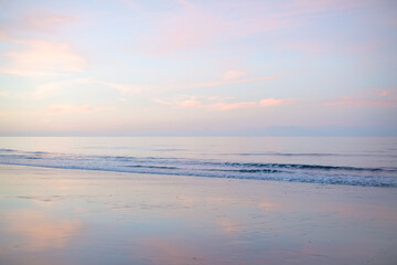 reverse sunset, Woodgate beach Queensland Australia, pastel pink clouds reflections sand, calm waves ripples ocean sea, coastal lifestyle, holiday vacation travel