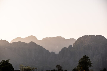 sun set through the mountain range at dusk in Vang Vieng, the adventure capital of Laos