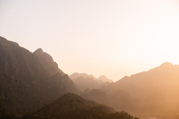 Obraz premium golden sunset over the ridges of mountains in Vang Vieng, the adventure capital of Laos
