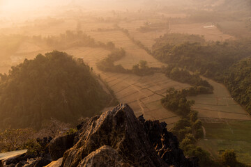 misty sunrise over the farmland in the valley in Vang Vieng, the adventure capital of Laos