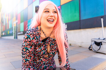 Nerdy girl with pink hair and headphones on her head