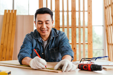 Portrait of a smile Asian male father sitting and working on the table with the instrument of...