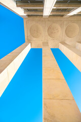Beautiful geometric abstraction of parts of architectural elements against a blue sky. Vertical...