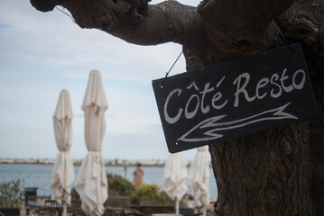 closeup of restaurant panel in french : cote resto, traduction in english, restaurant place on sea background