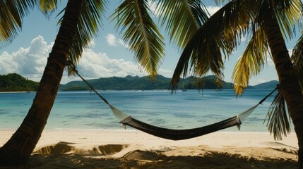 A hammock is swaying between two tall palm trees on a sandy beach, overlooking the crystalclear water and blue sky. The natural landscape is serene and perfect for relaxation AIG50