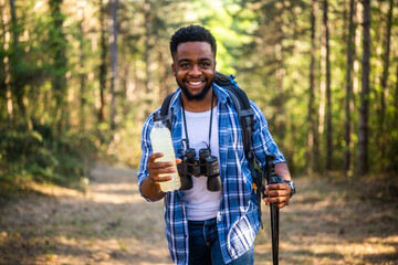 Young man enjoys  hiking and drinking energy drink.