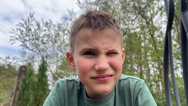 Close-up of the face of a teenager looking at the camera, grinning negatively, looking with contempt and dissatisfaction