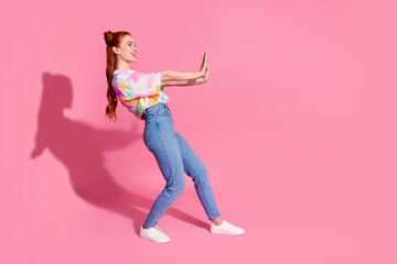 Fototapeta na wymiar Full size photo of positive girl dressed colorful blouse jeans hold palms say stop look empty space isolated on pink color background