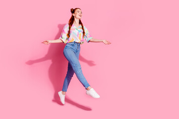 Full size photo of overjoyed pretty girl dressed colorful blouse flying look at offer empty space isolated on pink color background