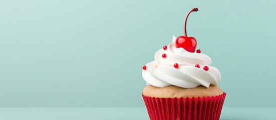A cupcake adorned with white buttercream decorative icing and a cherry atop it Perfect copy space image - obrazy, fototapety, plakaty