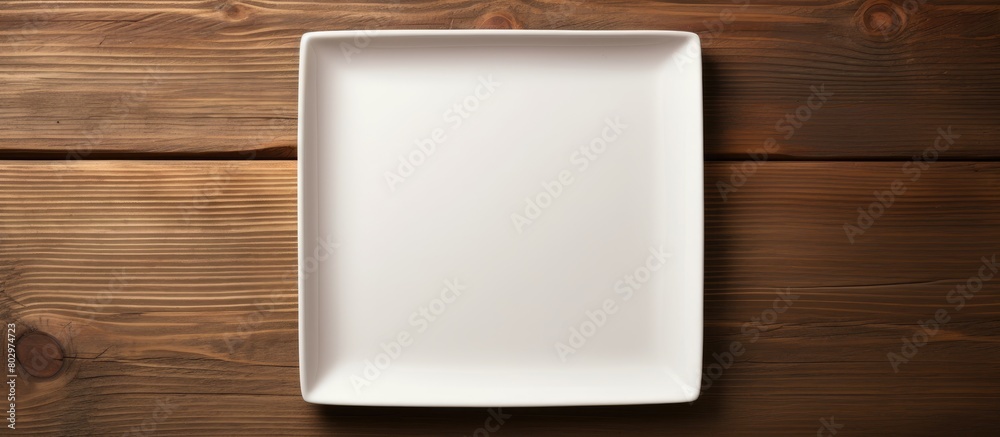 Poster A copy space image of an empty square plate placed on a wooden surface offering ample space for your own creative design