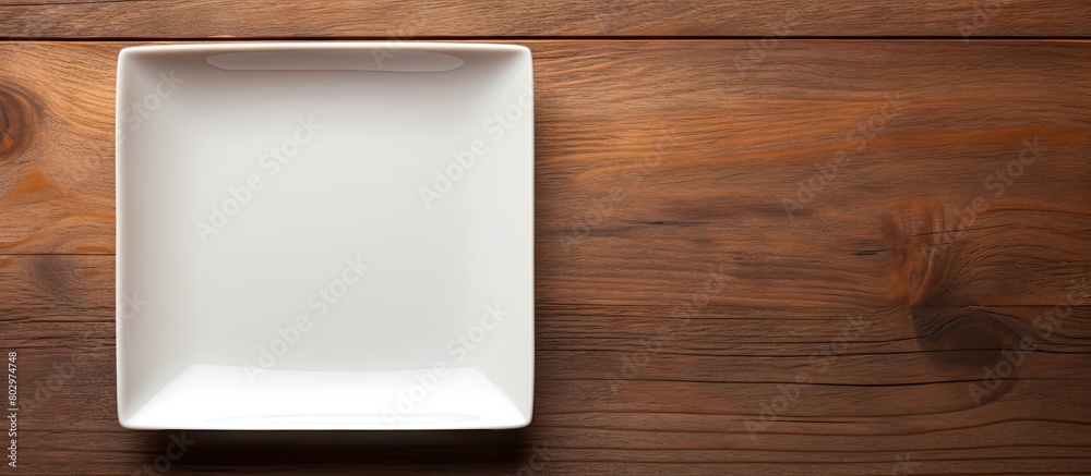 Poster A copy space image of an empty square plate placed on a wooden surface offering ample space for your own creative design