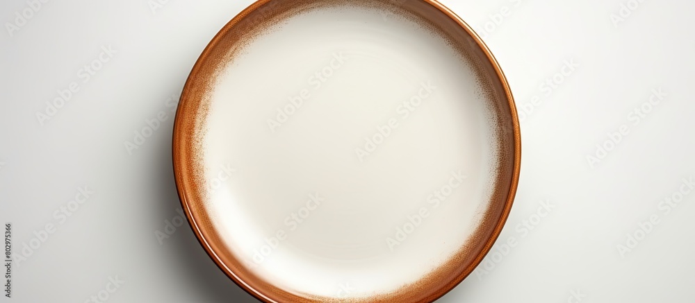 Fototapete A ceramic plate with a brown circle set on a white background is devoid of any objects with additional space for text or images